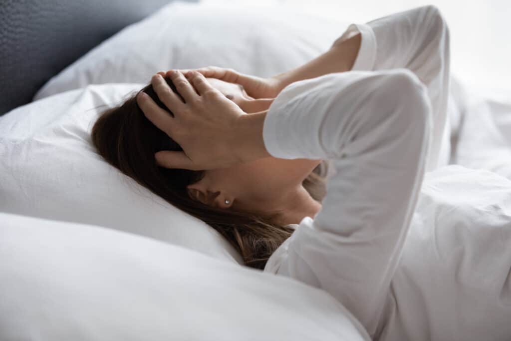 Woman in bed frustrated due to restless leg syndrome in Tampa, FL